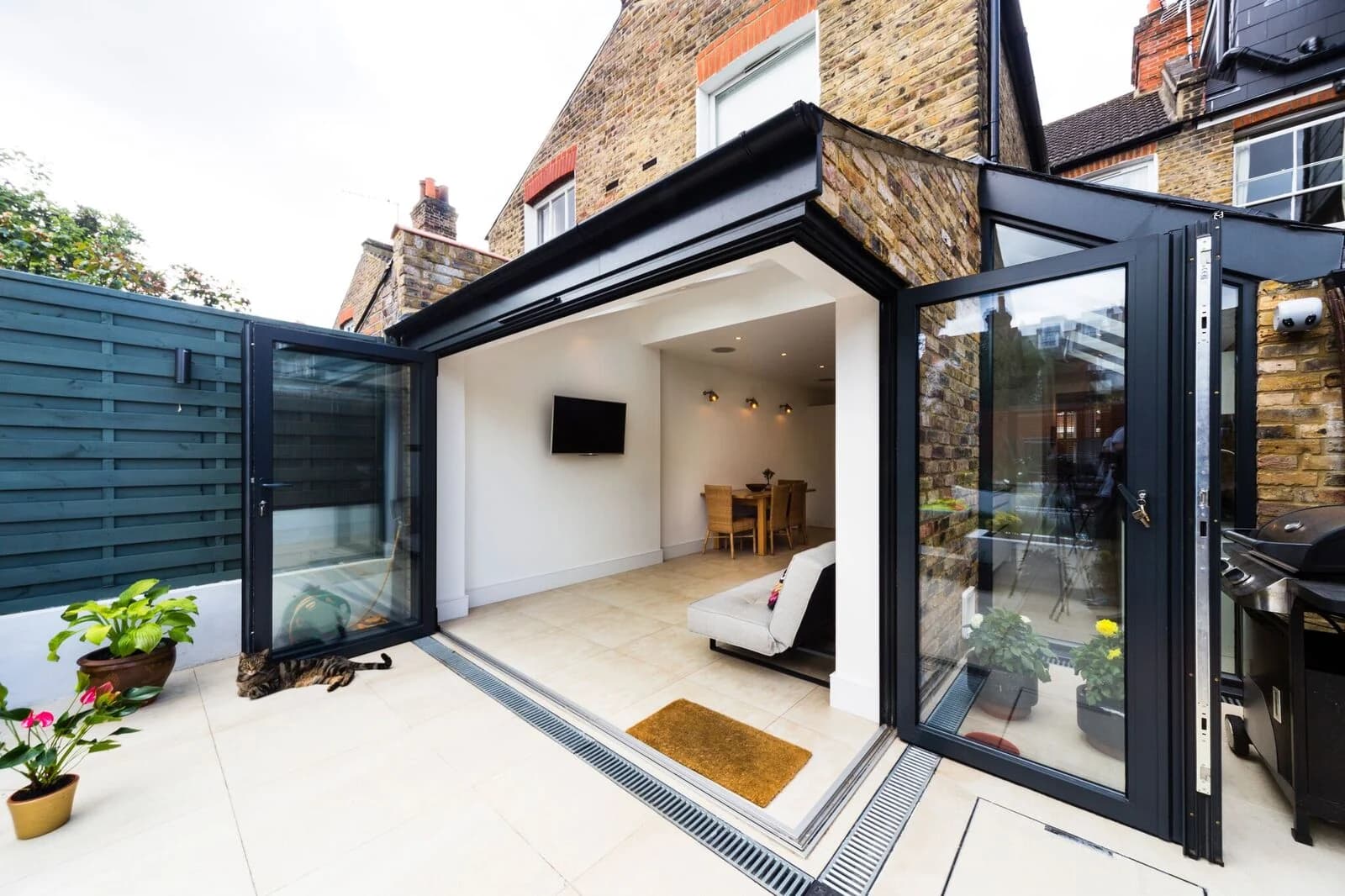 Rear house extension with folding glass doors opening onto a patio